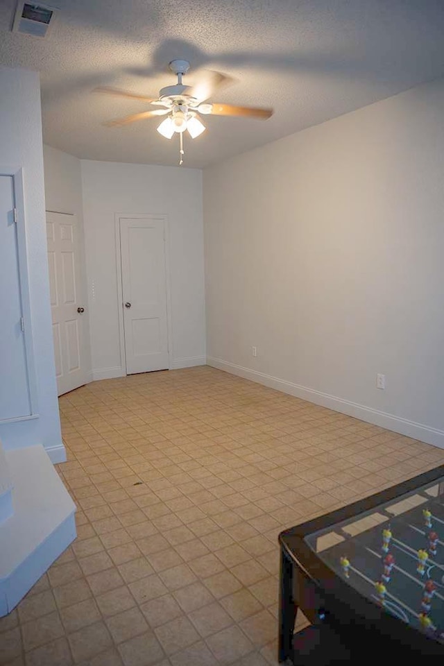 empty room featuring ceiling fan and a textured ceiling