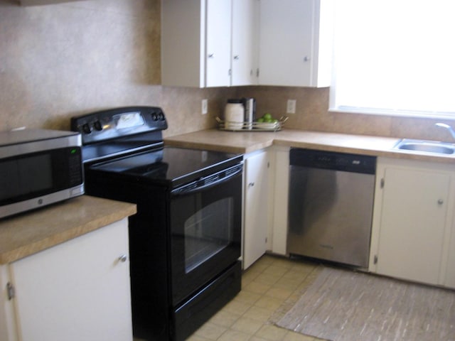 kitchen featuring sink, decorative backsplash, white cabinets, and appliances with stainless steel finishes