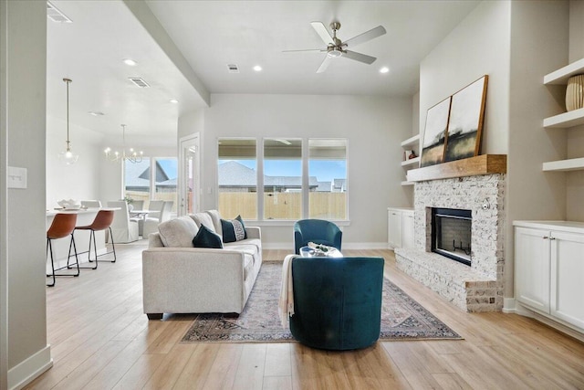 1403 Durham Ave, Wolfforth, TX 79382 - living room featuring light wood-style flooring, a fireplace, ceiling fan, a chandelier, and recessed lighting