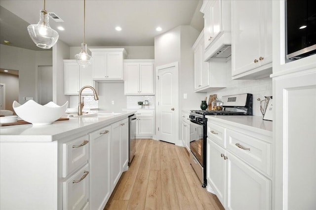1403 Durham Ave, Wolfforth, TX 79382 - kitchen with stainless steel appliances, tasteful backsplash, white cabinetry, recessed lighting, and light wood-style floors