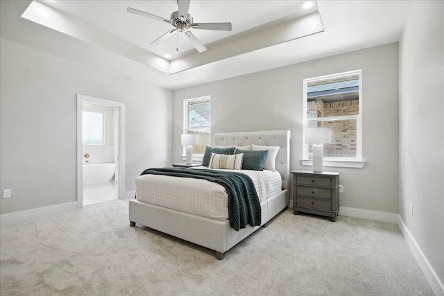 1403 Durham Ave, Wolfforth, TX 79382 - carpeted bedroom with a tray ceiling, ensuite bath, and a ceiling fan