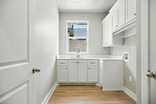 1403 Durham Ave, Wolfforth, TX 79382 - laundry room featuring hookup for a washing machine, light wood-style flooring, and cabinet space