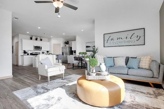 living room with hardwood / wood-style floors and ceiling fan