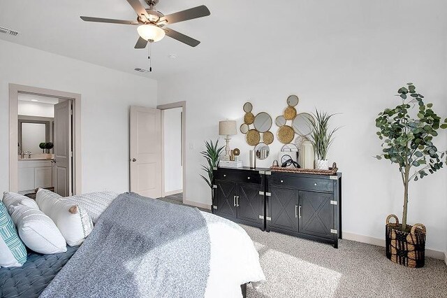 bedroom with ceiling fan, ensuite bath, and carpet flooring