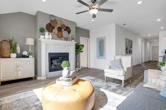 living room with ceiling fan, hardwood / wood-style floors, and a fireplace