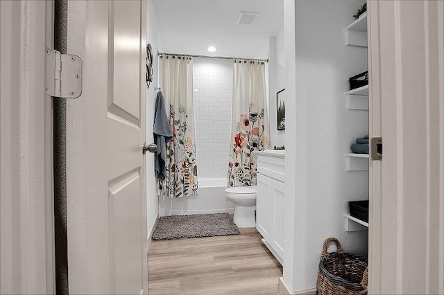 bathroom featuring shower / tub combo with curtain, toilet, and hardwood / wood-style floors