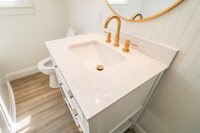 bathroom featuring vanity, hardwood / wood-style floors, and toilet