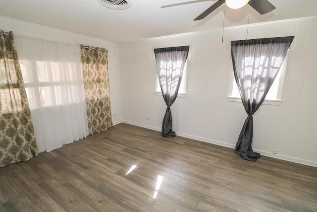 spare room with dark wood-type flooring, ceiling fan, and ornamental molding