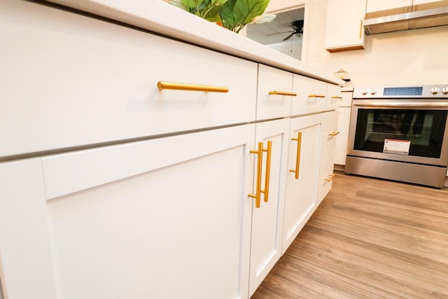 details featuring white cabinetry, light hardwood / wood-style flooring, stainless steel range with electric cooktop, and ceiling fan