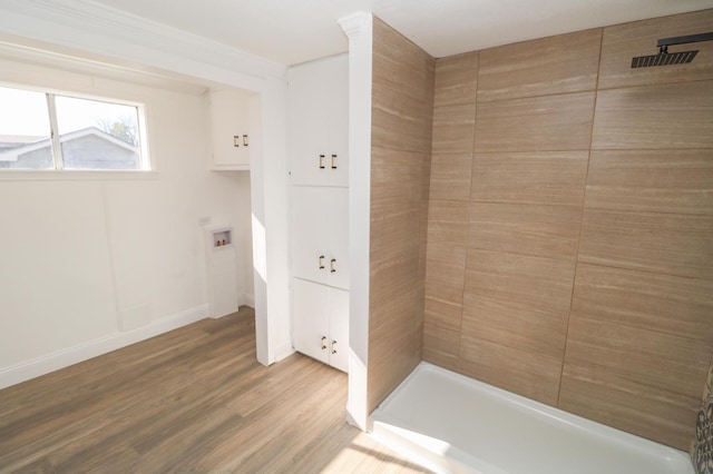 bathroom with wood-type flooring and tiled shower