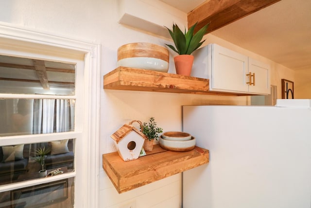 room details featuring white refrigerator and white cabinets