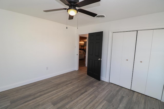 unfurnished bedroom featuring dark wood-type flooring, a closet, and ceiling fan