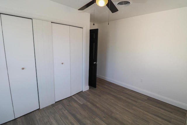 unfurnished bedroom with dark hardwood / wood-style floors, a closet, and ceiling fan