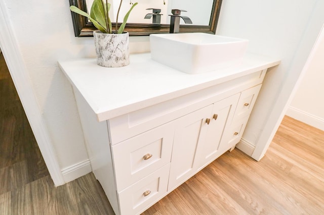 details with vanity and hardwood / wood-style floors