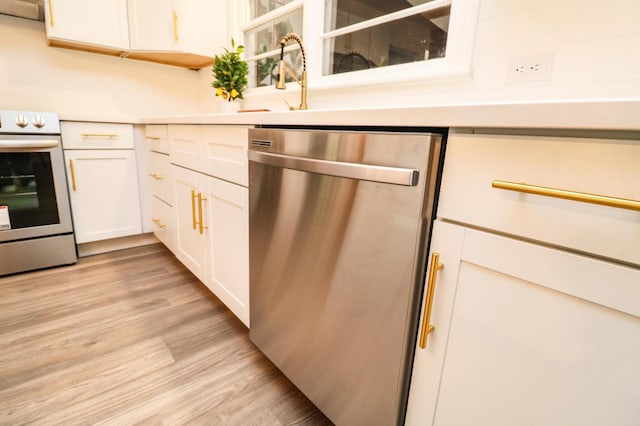 kitchen featuring white cabinetry, stainless steel appliances, sink, and light hardwood / wood-style floors