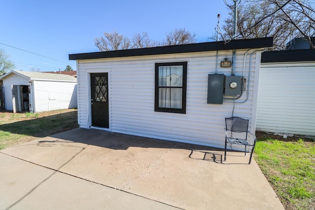 view of front facade featuring an outbuilding and a patio area