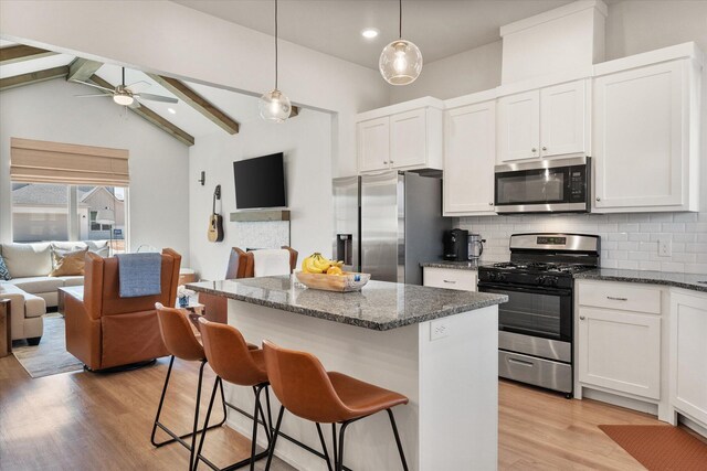 5908 Grinnell St, Lubbock, TX 79416 - kitchen featuring appliances with stainless steel finishes, open floor plan, a ceiling fan, tasteful backsplash, and light wood finished floors