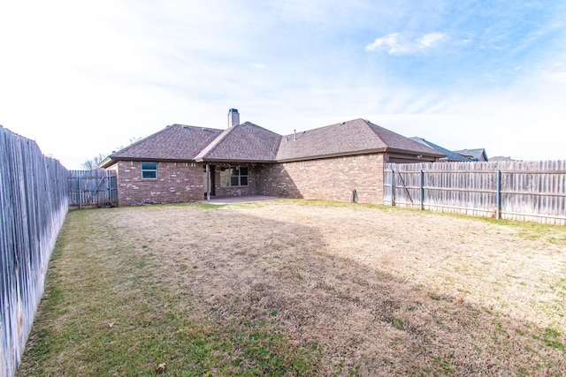 rear view of house featuring a yard