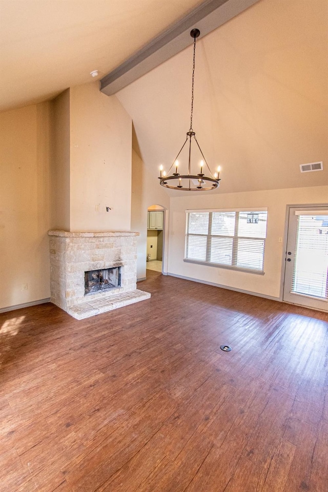 unfurnished living room with hardwood / wood-style floors, beam ceiling, and a fireplace