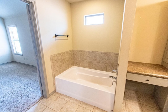 bathroom featuring tile patterned flooring, a tub, and a wealth of natural light