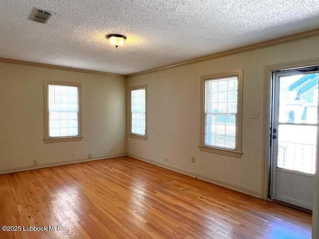 2413 25th St, Lubbock, TX 79411 - empty room with ornamental molding, light wood finished floors, a textured ceiling, and baseboards