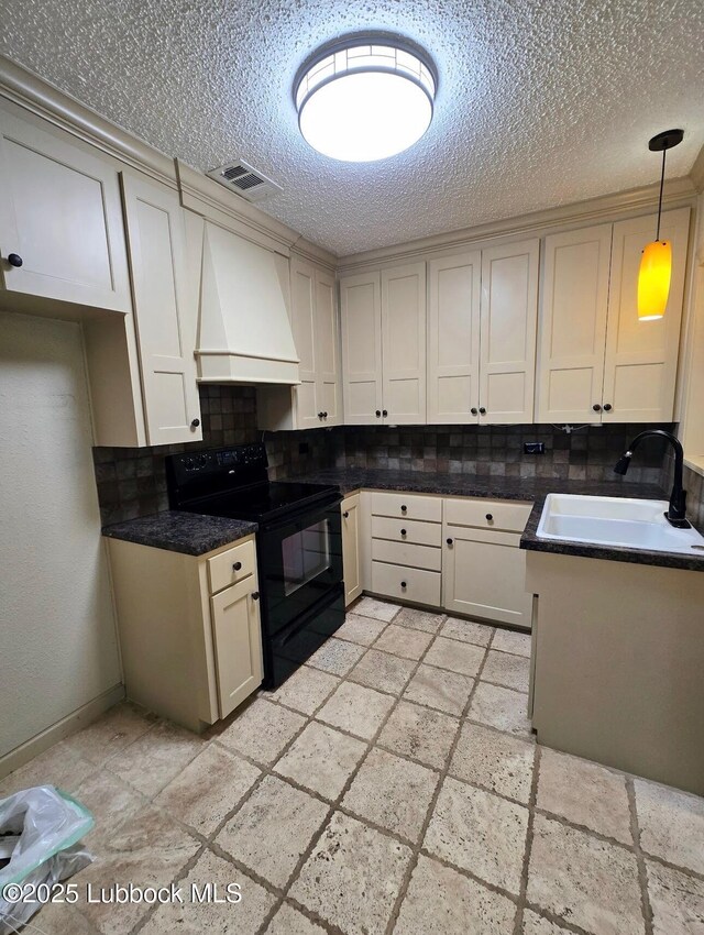 2413 25th St, Lubbock, TX 79411 - kitchen with black electric range, custom range hood, a sink, backsplash, and stone tile flooring
