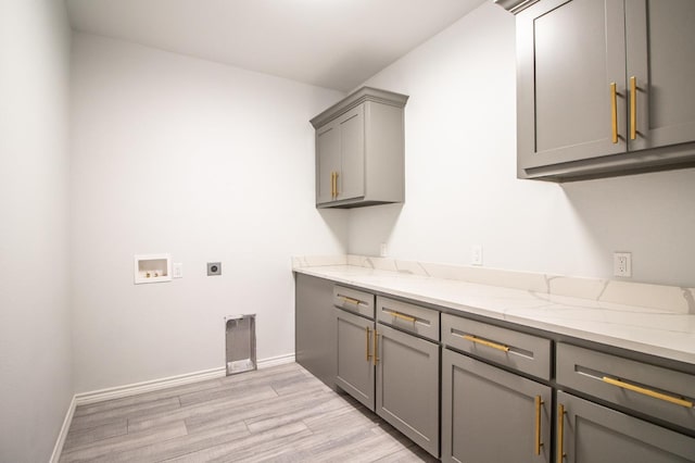 laundry room featuring cabinets, hookup for a washing machine, hookup for an electric dryer, and light wood-type flooring