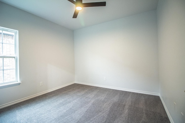 spare room with ceiling fan and dark carpet