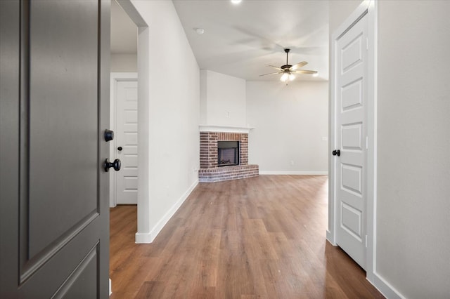 unfurnished living room featuring hardwood / wood-style floors, a fireplace, and ceiling fan