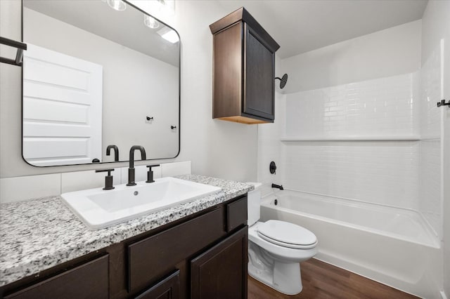 full bathroom featuring shower / washtub combination, hardwood / wood-style floors, vanity, and toilet