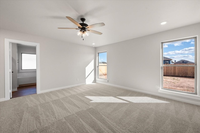 carpeted spare room featuring ceiling fan