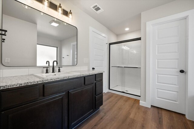 bathroom featuring vanity, hardwood / wood-style floors, and walk in shower