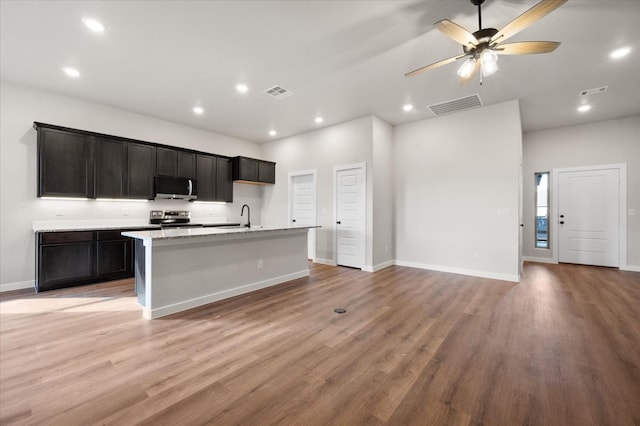 kitchen featuring sink, a kitchen island with sink, ceiling fan, stainless steel appliances, and light hardwood / wood-style flooring