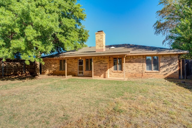 back of house featuring a lawn and a patio area