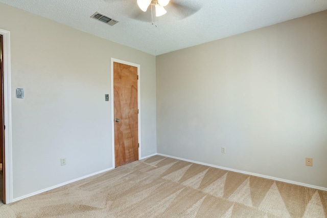 spare room featuring carpet floors, a textured ceiling, and ceiling fan