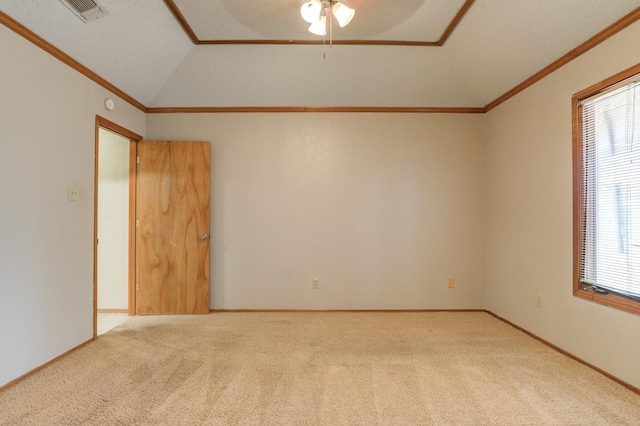 carpeted spare room with a textured ceiling, ornamental molding, lofted ceiling, and a healthy amount of sunlight