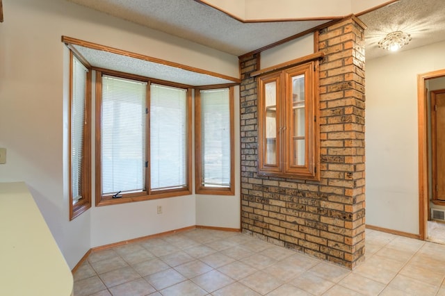 spare room with light tile patterned floors and a textured ceiling