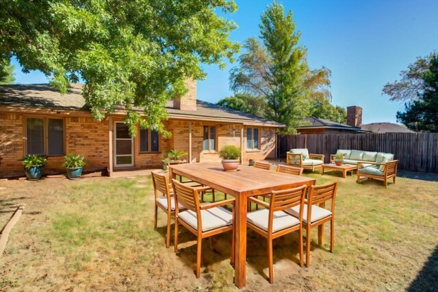 back of property with a lawn, a patio, and an outdoor hangout area