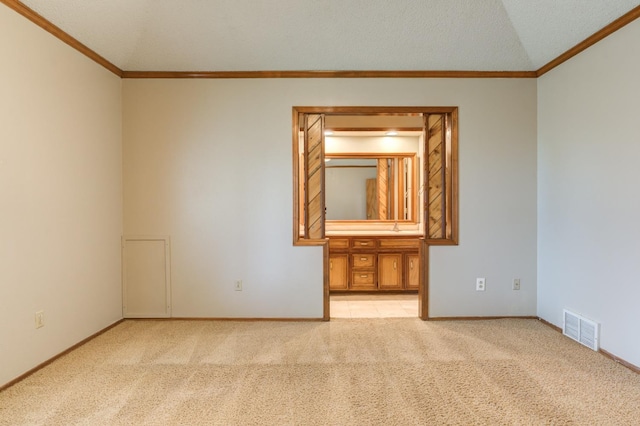 carpeted spare room with a textured ceiling and ornamental molding