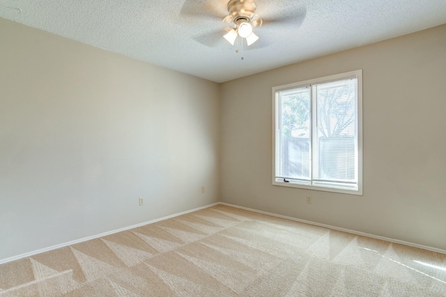 carpeted empty room featuring ceiling fan and a textured ceiling