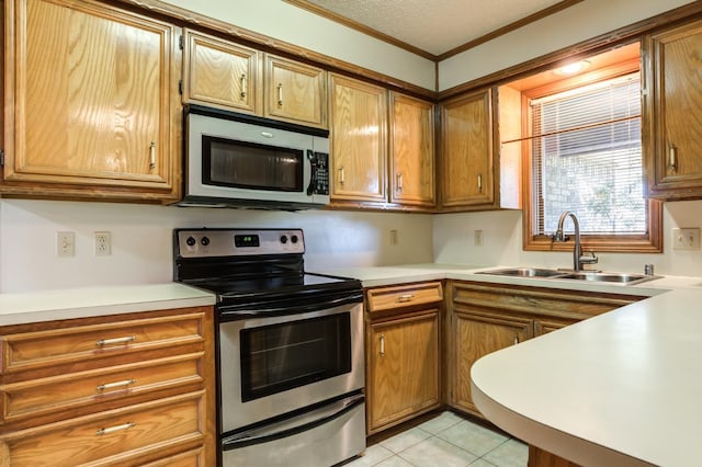 kitchen featuring stainless steel appliances, a textured ceiling, crown molding, light tile patterned floors, and sink