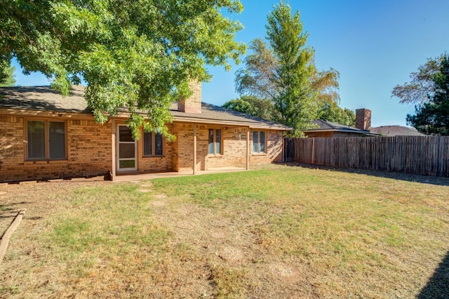 back of property featuring a yard and a patio area