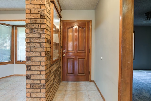 doorway featuring light tile patterned floors and a textured ceiling