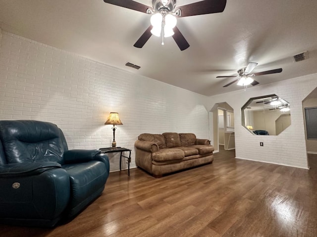 living room with ceiling fan, brick wall, and wood-type flooring