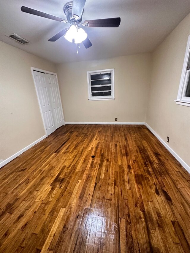 unfurnished bedroom with ceiling fan, wood-type flooring, and a closet