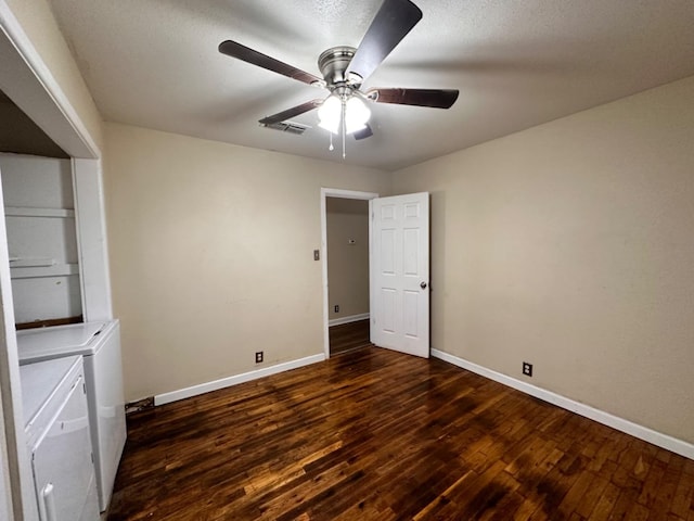 unfurnished room featuring ceiling fan, dark wood-type flooring, and washer and clothes dryer