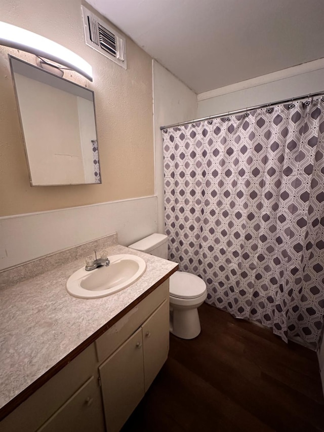 bathroom with vanity, hardwood / wood-style flooring, and toilet