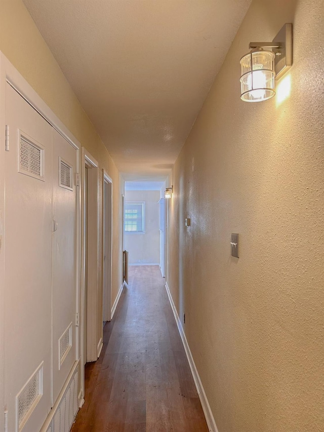 hallway with dark hardwood / wood-style flooring