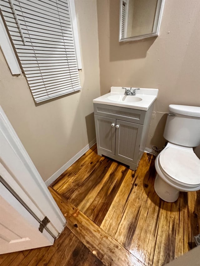 bathroom featuring vanity, hardwood / wood-style flooring, and toilet