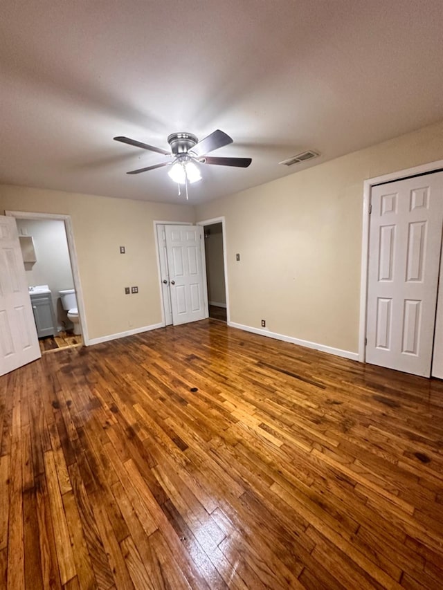 unfurnished bedroom with hardwood / wood-style flooring, ceiling fan, and ensuite bathroom